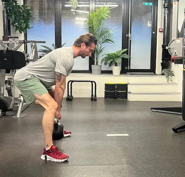 Man performing a sumo Romanian deadlift