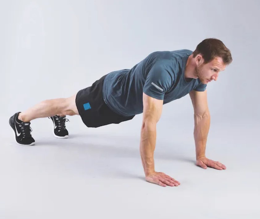 Man performing a wide mountain climber stretch