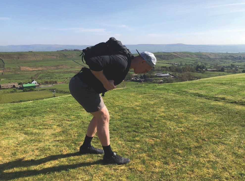 Man exercising outdoors with a loaded backpack