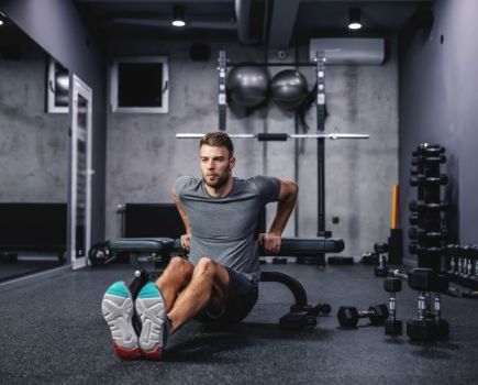 Man doing triceps dips in a gym