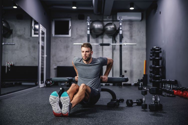 Man doing triceps dips in a gym