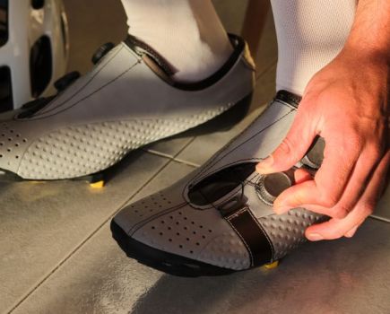 Close-up of a man putting on cycling shoes