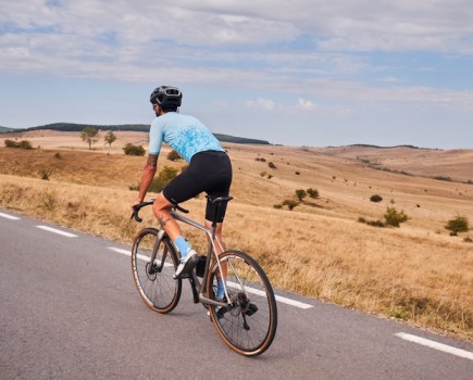 A man in cycling kit riding along a quiet road