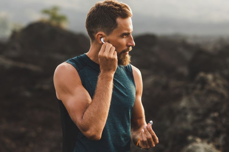 A male runner putting headphones in