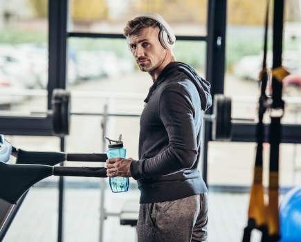 Man wearing a hoodie in a gym