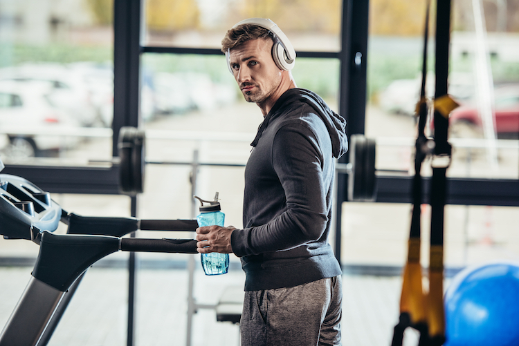 Man wearing a hoodie in a gym