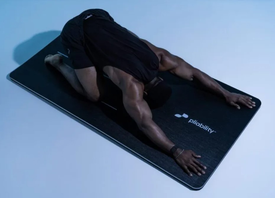 Man performing a child's pose on an exercise mat