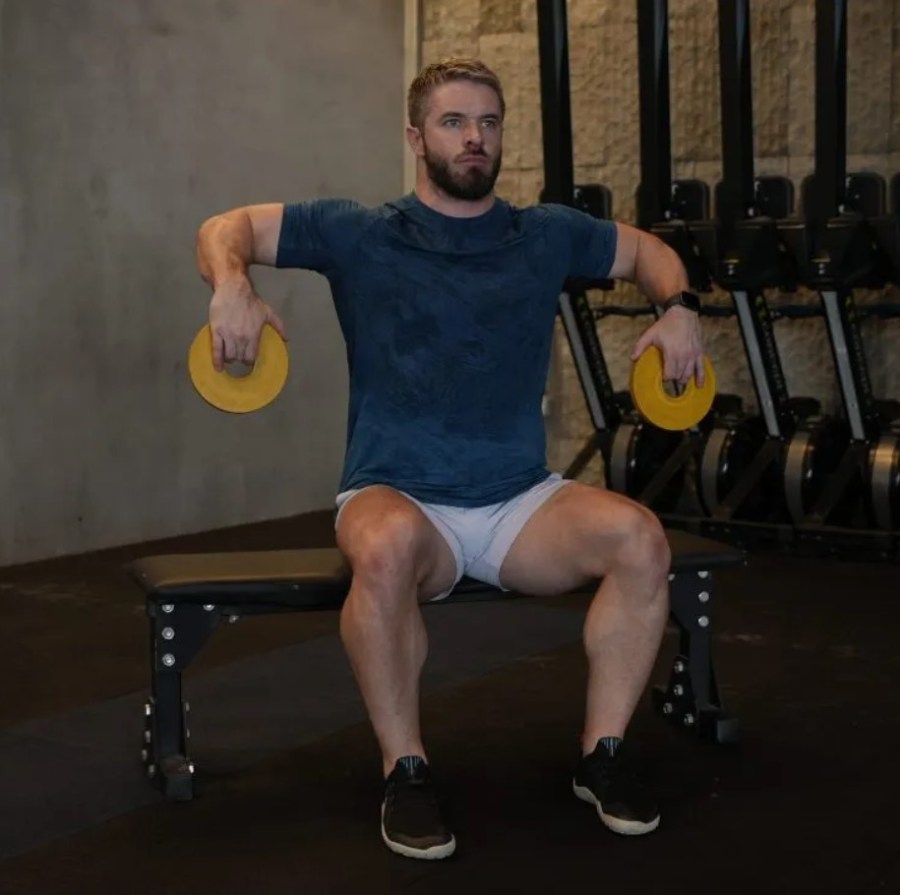 Man performing a Cuban press exercise