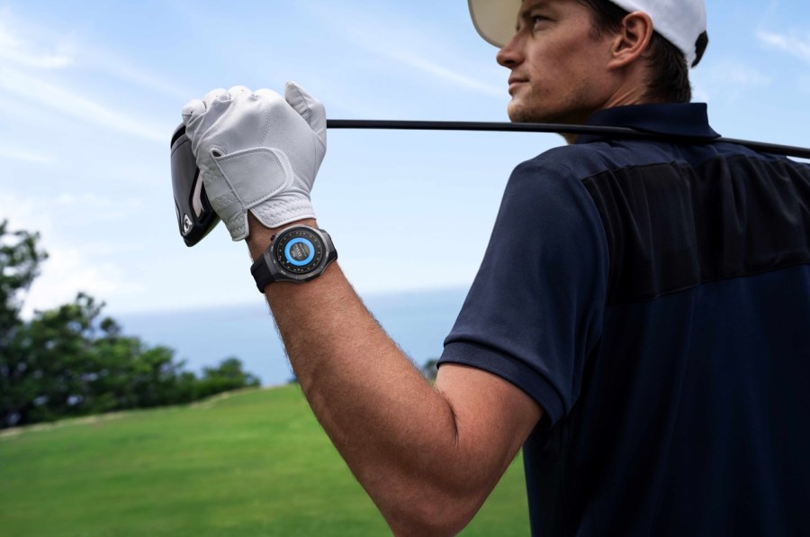 Man wearing a Huawei watch and holding a golf club