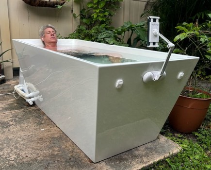 A man lying in an outdoor ice bath