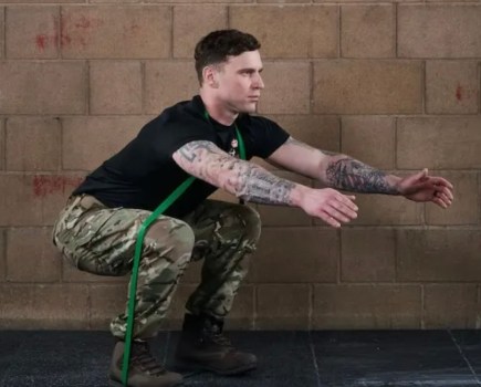 Man squatting while exercising with resistance bands