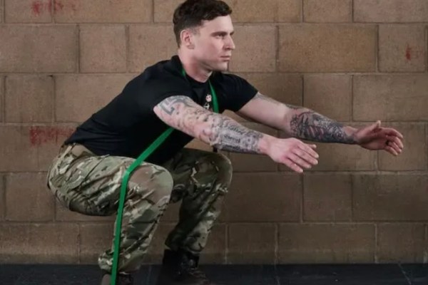 Man squatting while exercising with resistance bands