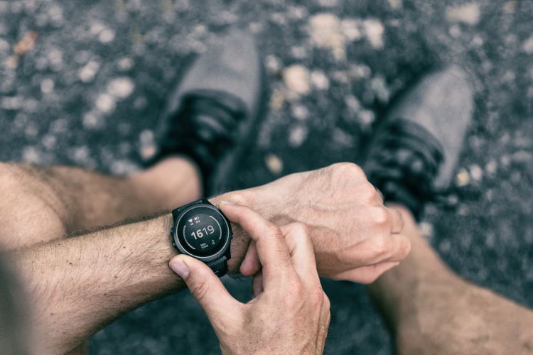 Close-up of a man's hand operating a running watch