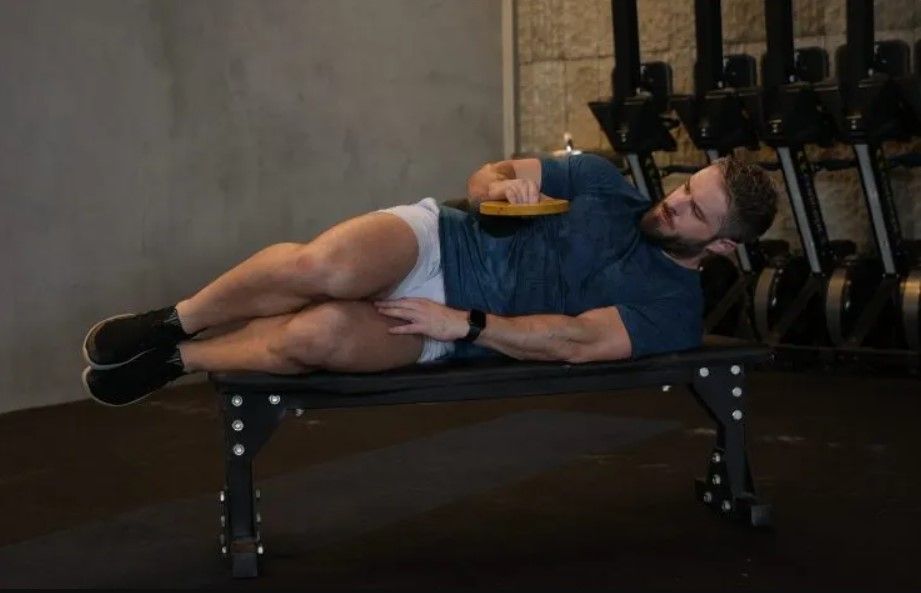 Man on a bench performing a side-lying external rotation exercise