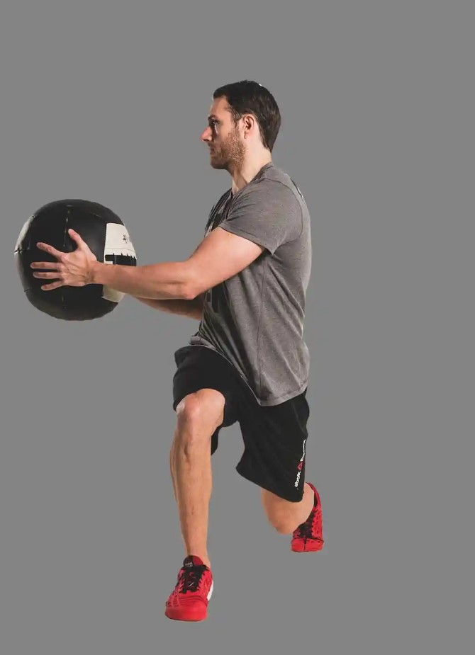 Man performing a medicine ball lunge and twist