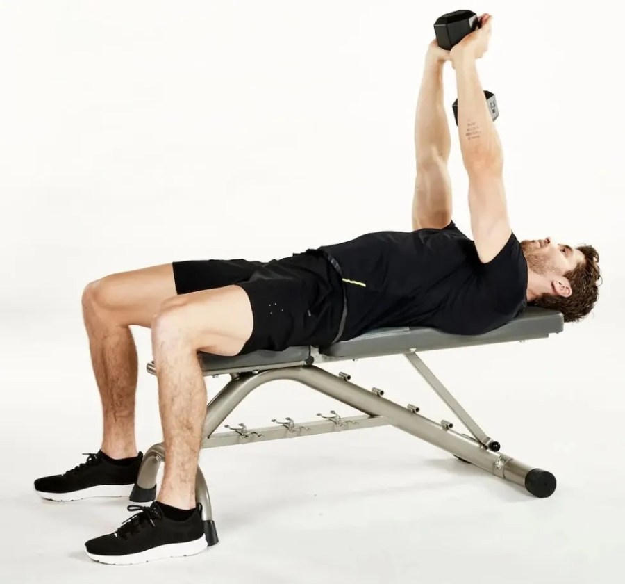 Man on a weight bench performing a dumbbell pullover