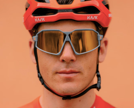 Close-up of a male cyclist wearing a helmet and cycling glasses