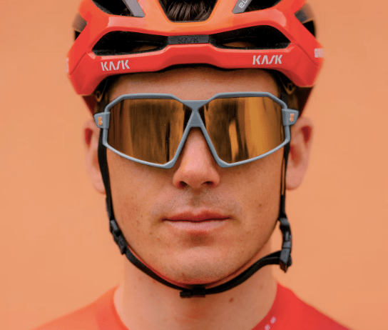 Close-up of a male cyclist wearing a helmet and cycling glasses