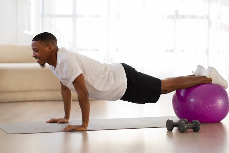 Man using an exercise ball at home