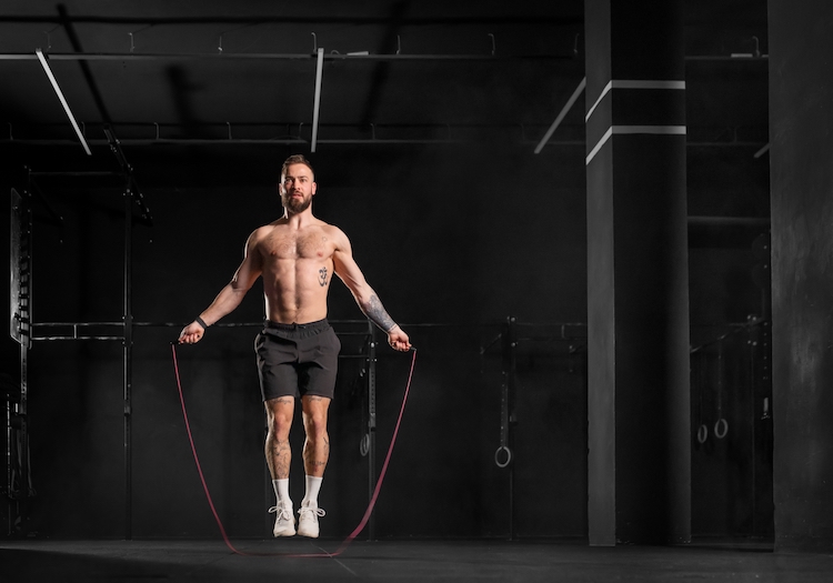 A man skipping in a gym wearing gym shorts