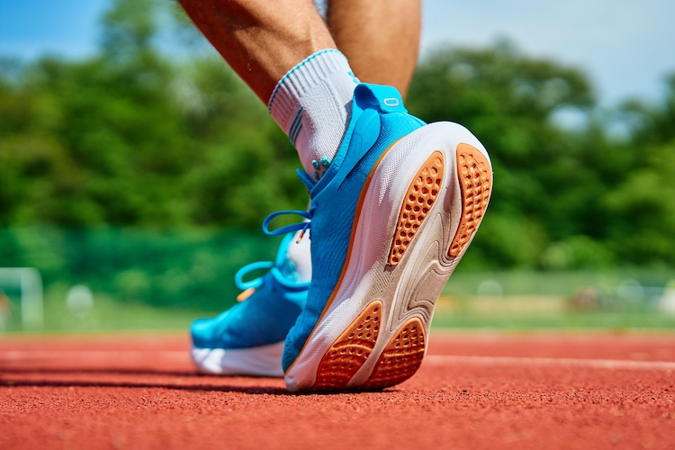 Close of a man's feet in running shoes on an outdoor track