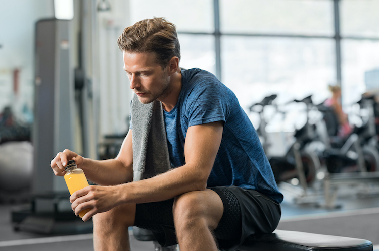 Man in a gym with a bottle of electrolyte drink