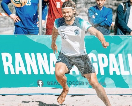 A man playing beach football