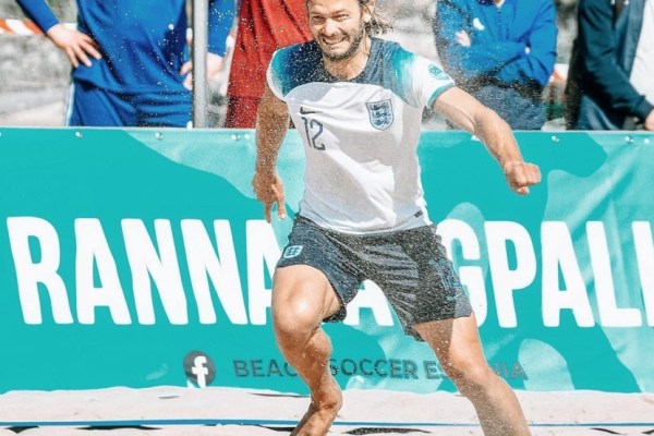 A man playing beach football