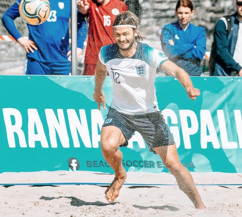 A man playing beach football