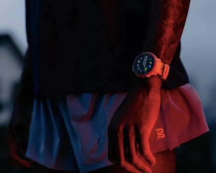 Close-up of a man in running shorts wearing a running watch