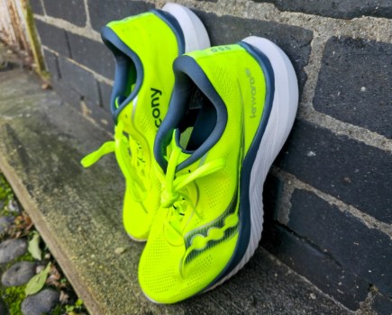 Pair of yellow running shoes propped up against a wall