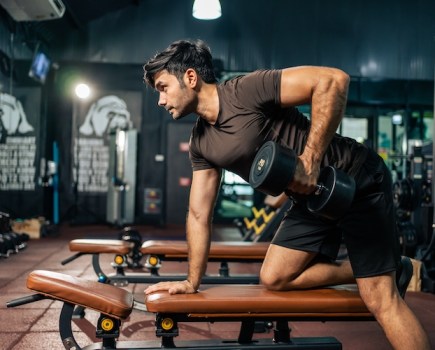 Man working out with dumbbells in a gym