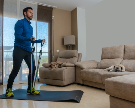 A man exercising with resistance bands at home