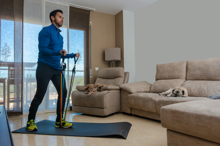 A man exercising with resistance bands at home