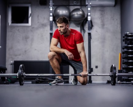 Man resting in the gym between barbell workout