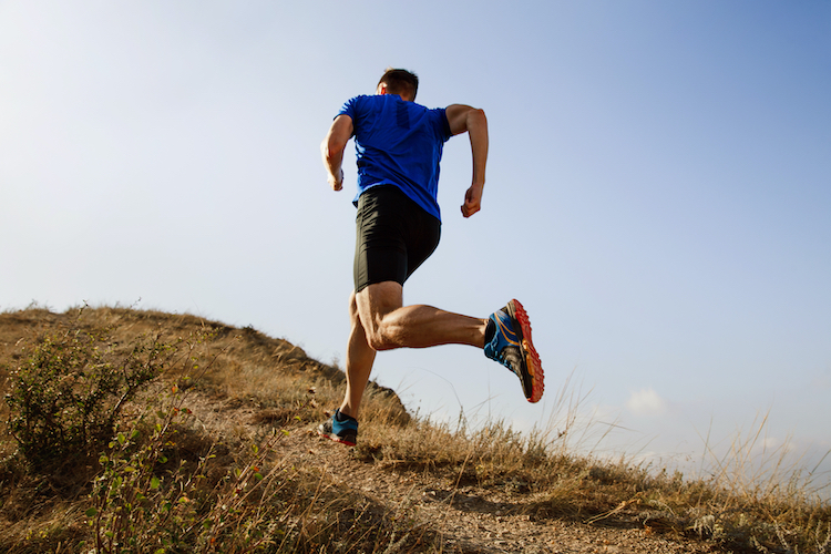 Man in shorts running up a hill