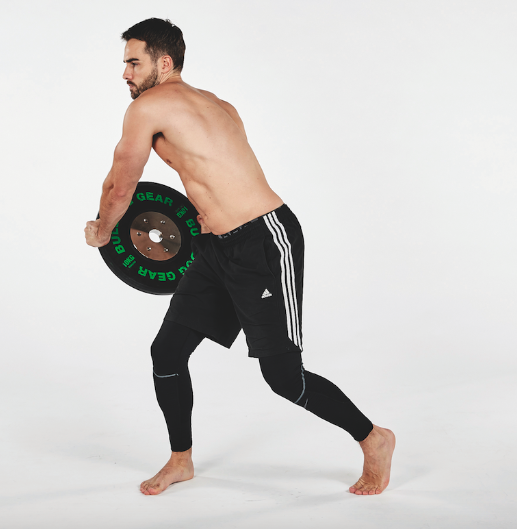 Man performing a chop exercise with a weight plate