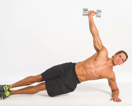 Man performing a dumbbell side plank exercise