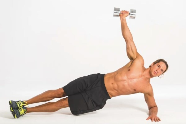 Man performing a dumbbell side plank exercise