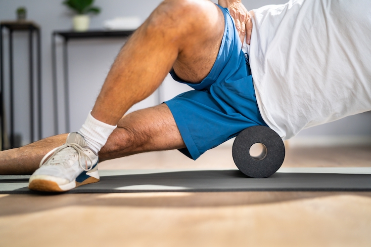 Close-up of a man's mid torso exercising with a foam roller