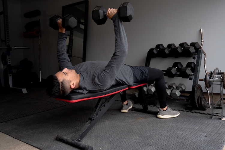 Man bench pressing in a home gym