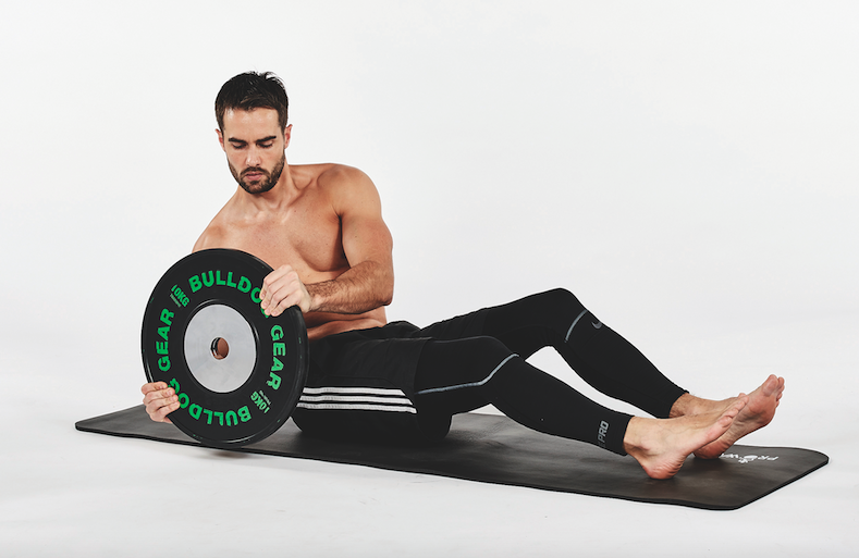 Man performing a Russian twist with a weight plate