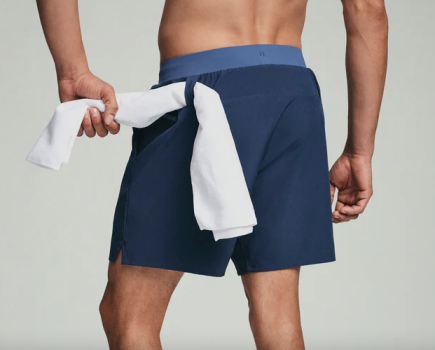 Close-up of a man with a towel looped through his gym shorts