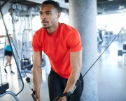 Close-up of of a man using an exercise machine in a gym