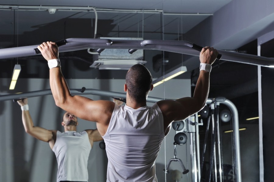 man in gym performing pull-up as part of a functional training plan