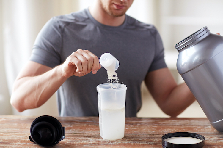 A man mixing a clear protein drink