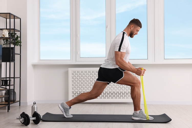 Man exercising on a mat with resistance bands