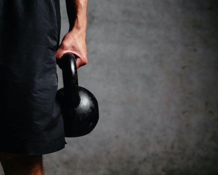 Close up of a man holding a kettlebell