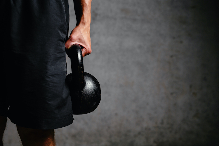 Close up of a man holding a kettlebell