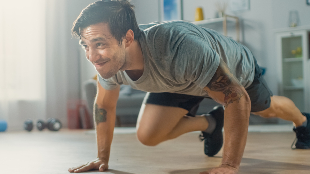 Man working hard doing mountain climbers in a small space